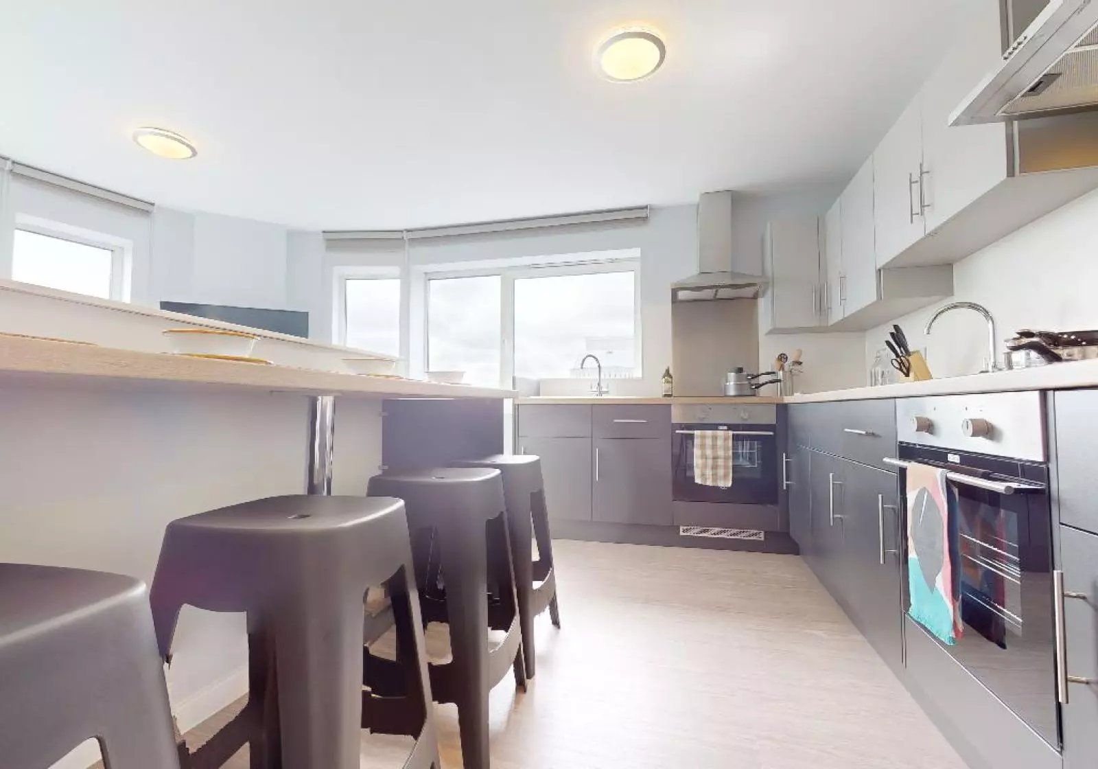 Stools by counter with ovens and sink kitchen at iQ Highbury in London Student Accommodation