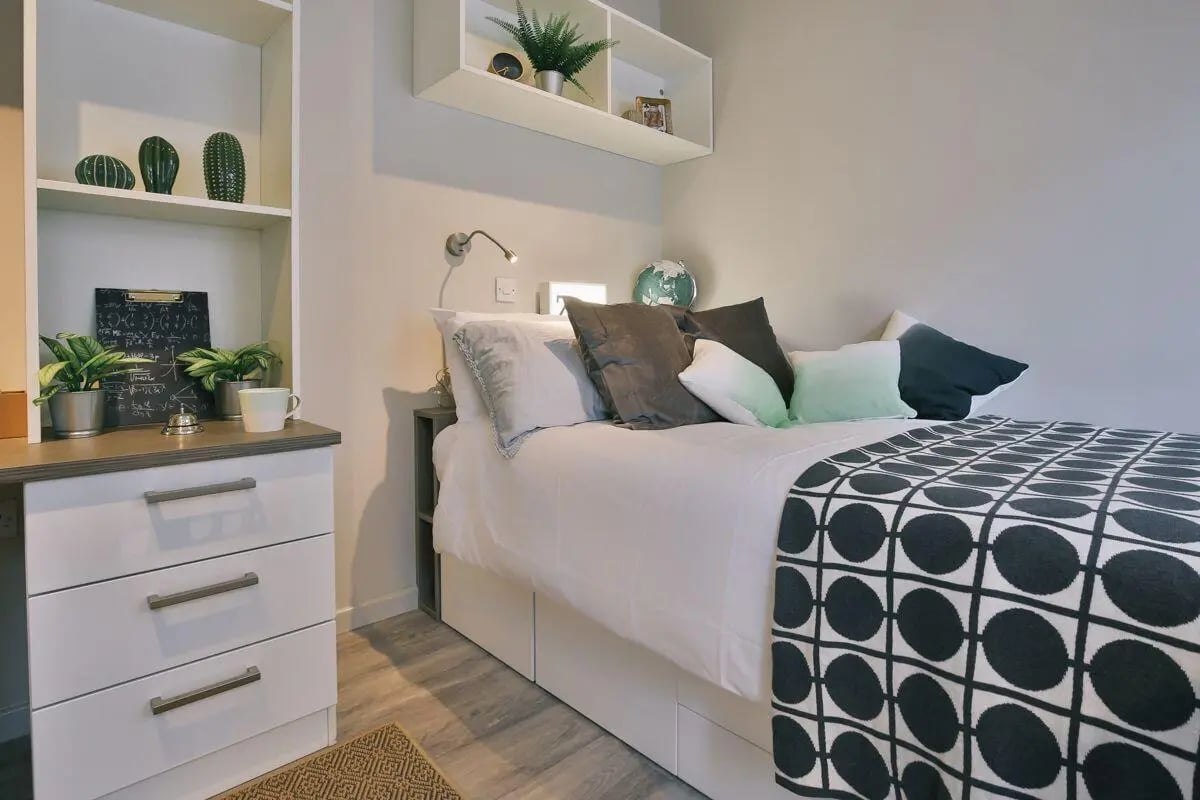 Bed with pillows and patterned throw Bedroom at The Chapel in Manchester Student Accommodation