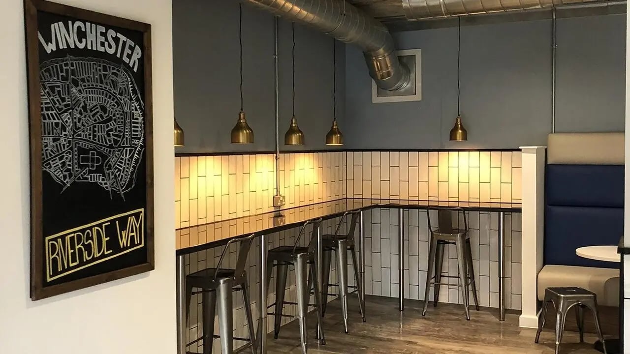 Bar stools and booth seating communal area at Collegiate Riverside Way Winchester in Winchester Student Accommodation