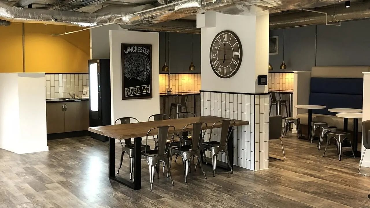 Wooden dining table chairs kitchen and seating area at Collegiate Riverside Way Winchester in Winchester Student Accommodation