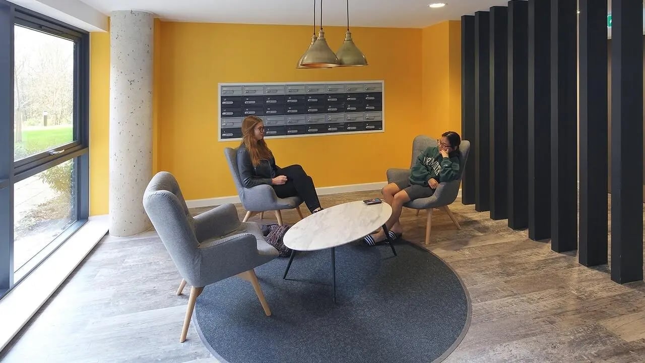 Two students seated in lounge area. at Collegiate Riverside Way Winchester in Winchester Student Accommodation