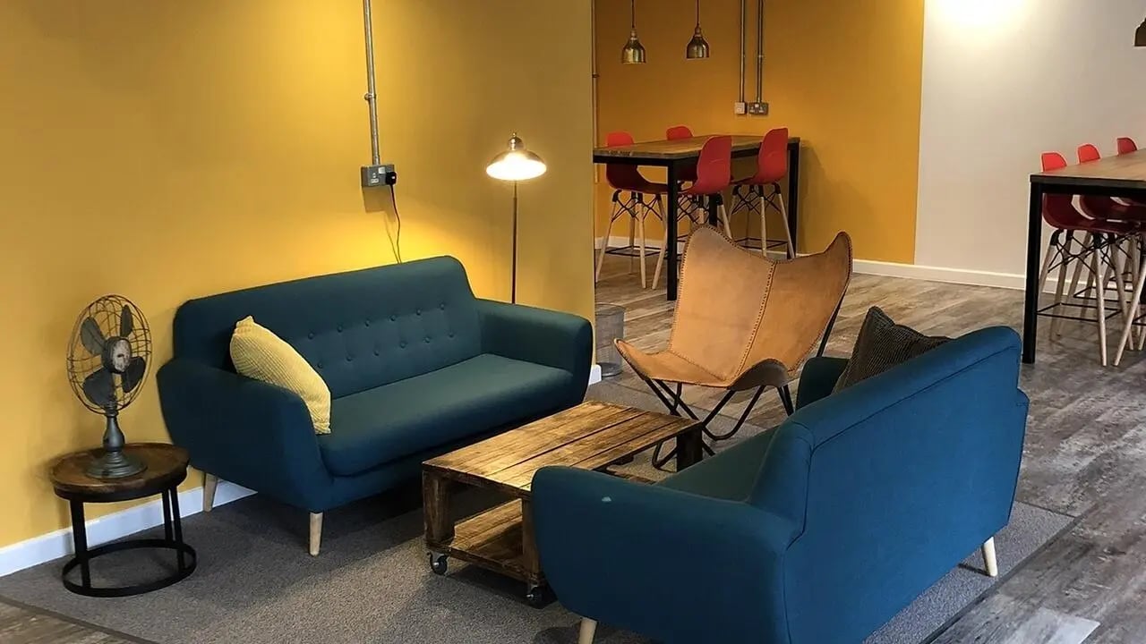 Blue sofas wooden table fan living room at Collegiate Riverside Way Winchester in Winchester Student Accommodation