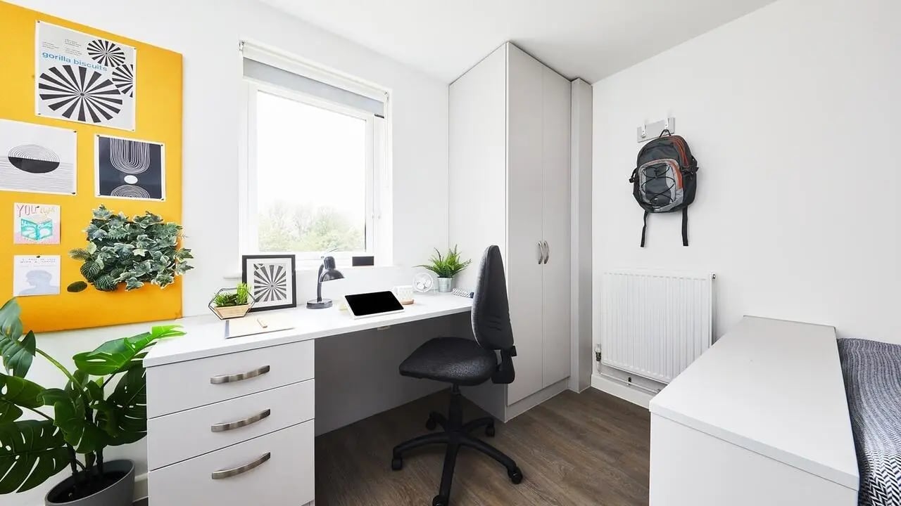 Desk plants laptop backpack and bed bedroom at Collegiate Riverside Way Winchester in Winchester Student Accommodation