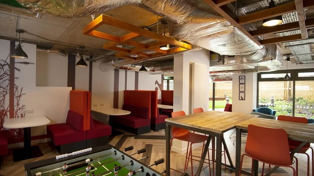 Foosball table booths tables chairs communal room at Collegiate Cathedral Point in Winchester Student Accommodation