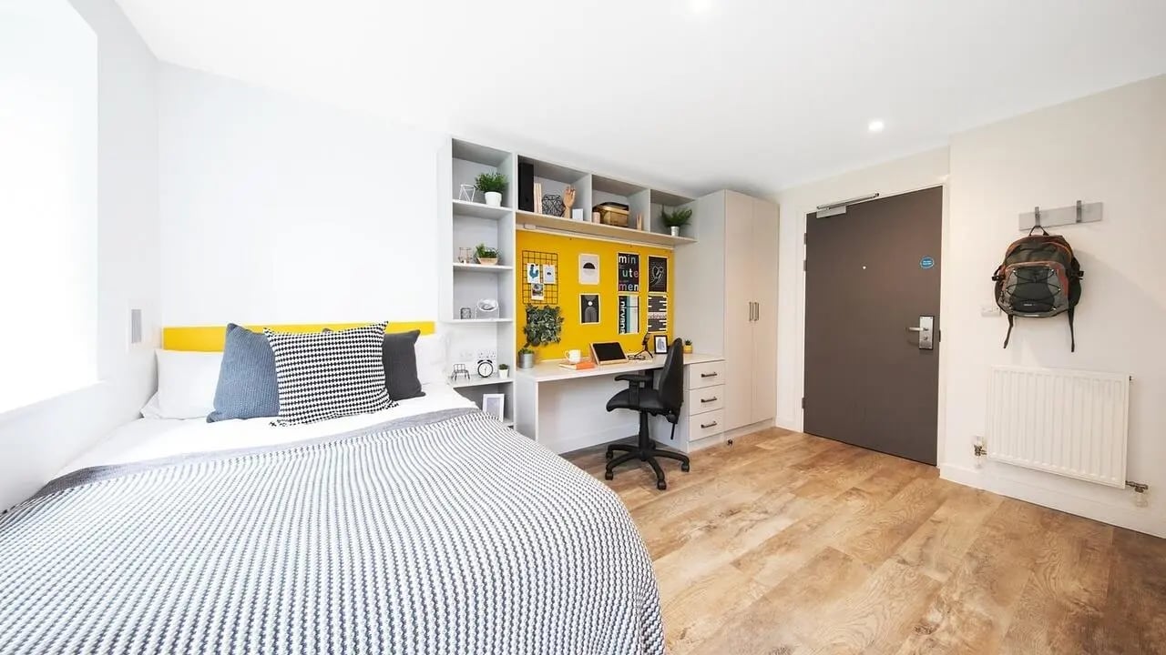 Bed desk and backpack in student studio bedroom at Collegiate Cathedral Point in Winchester Student Accommodation