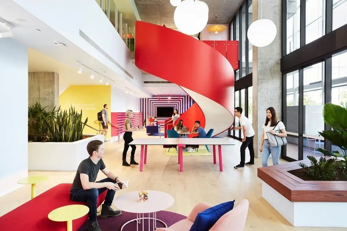 Modern lounge area with students and spiral staircase lounge area at Scape Toowong in Brisbane Student Accommodation