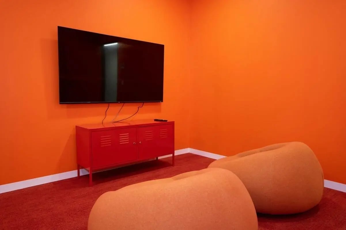 Orange bean bags red cabinet flat screen TV living room at Scape Toowong in Brisbane Student Accommodation