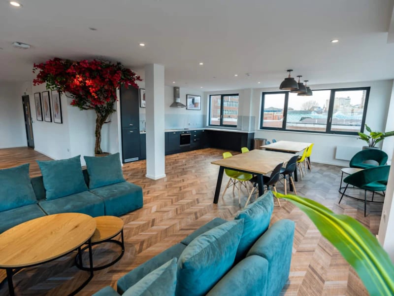Teal sofas coffee tables kitchen and dining tables living room at Steelworks in Sheffield Student Accommodation