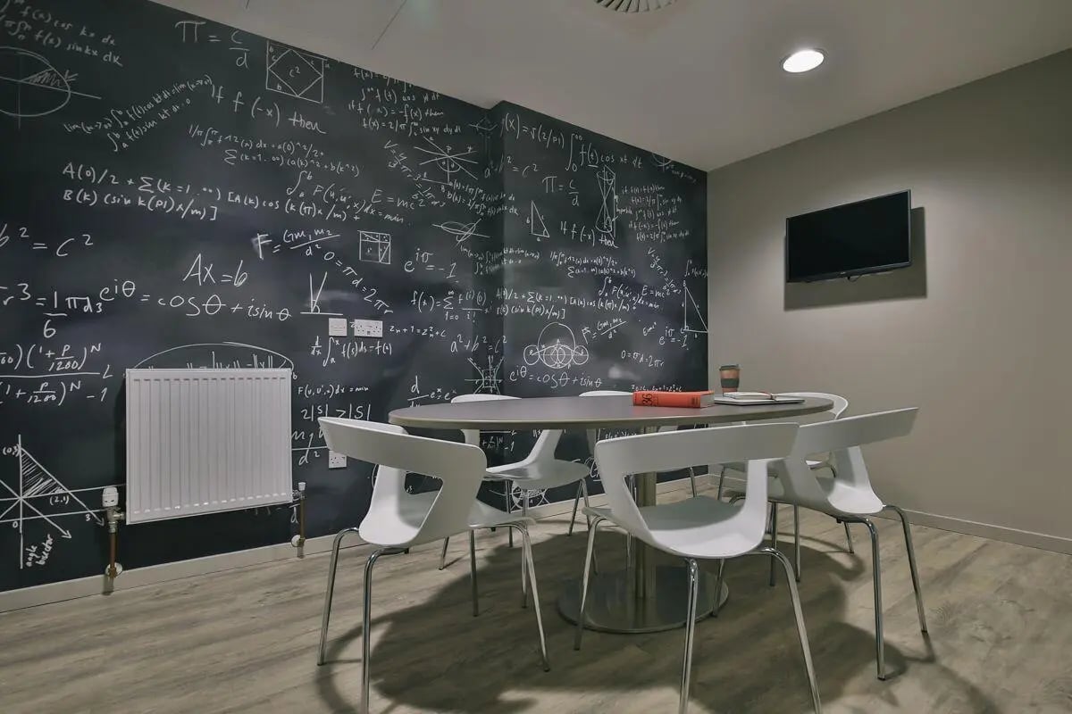 Chalkboard wall table chairs television study area at George Street Apartments in Glasgow Student Accommodation