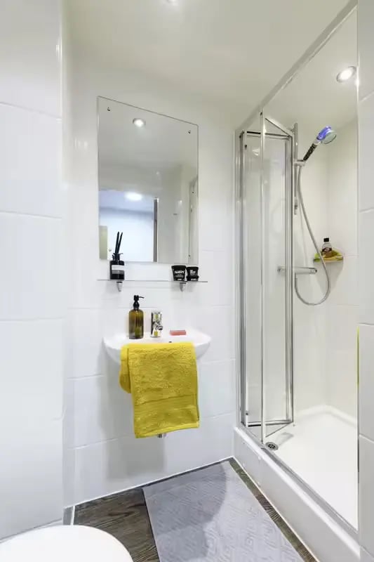 Sink shower and yellow towel bathroom at The Elements in Sheffield Student Accommodation