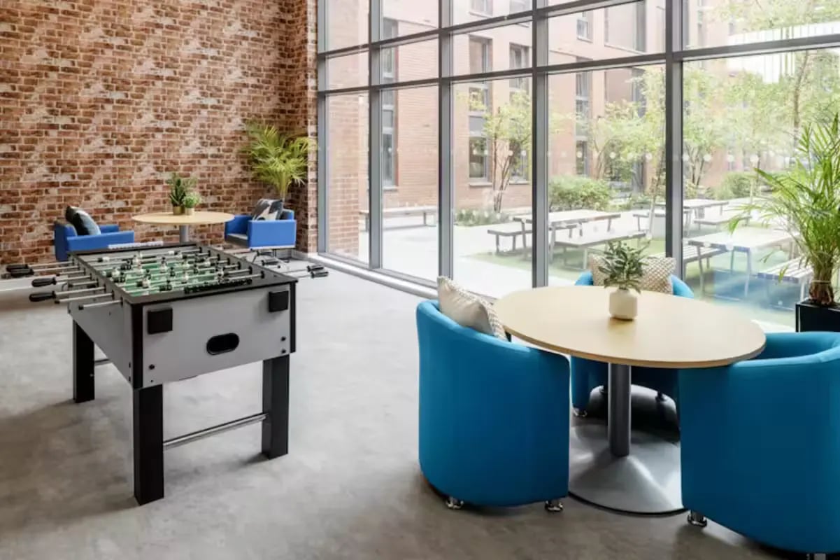 Foosball table blue chairs round table common area at The Elements in Sheffield Student Accommodation