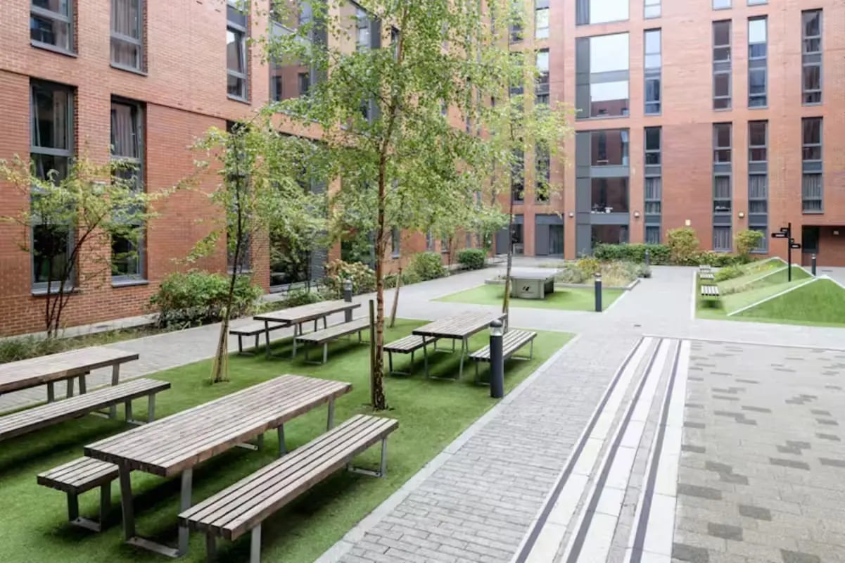 Wooden picnic tables and benches exterior at The Elements in Sheffield Student Accommodation
