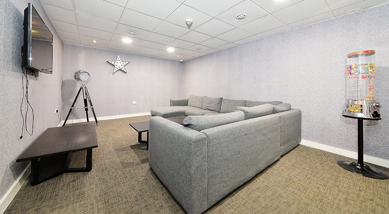 Grey sectional sofa TV and candy machine living room at 88 Bromsgrove House in Birmingham Student Accommodation