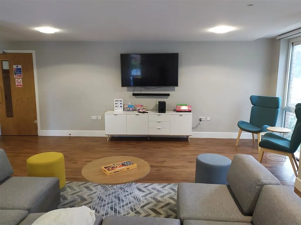 Sofa chess board TV and chairs living room at Davidson House in Kingston Upon Thames Student Accommodation