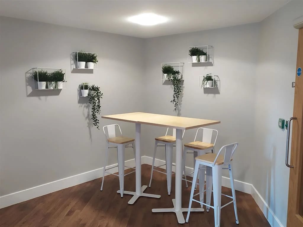 Wooden table four stools plants communal area at Davidson House in Kingston Upon Thames Student Accommodation