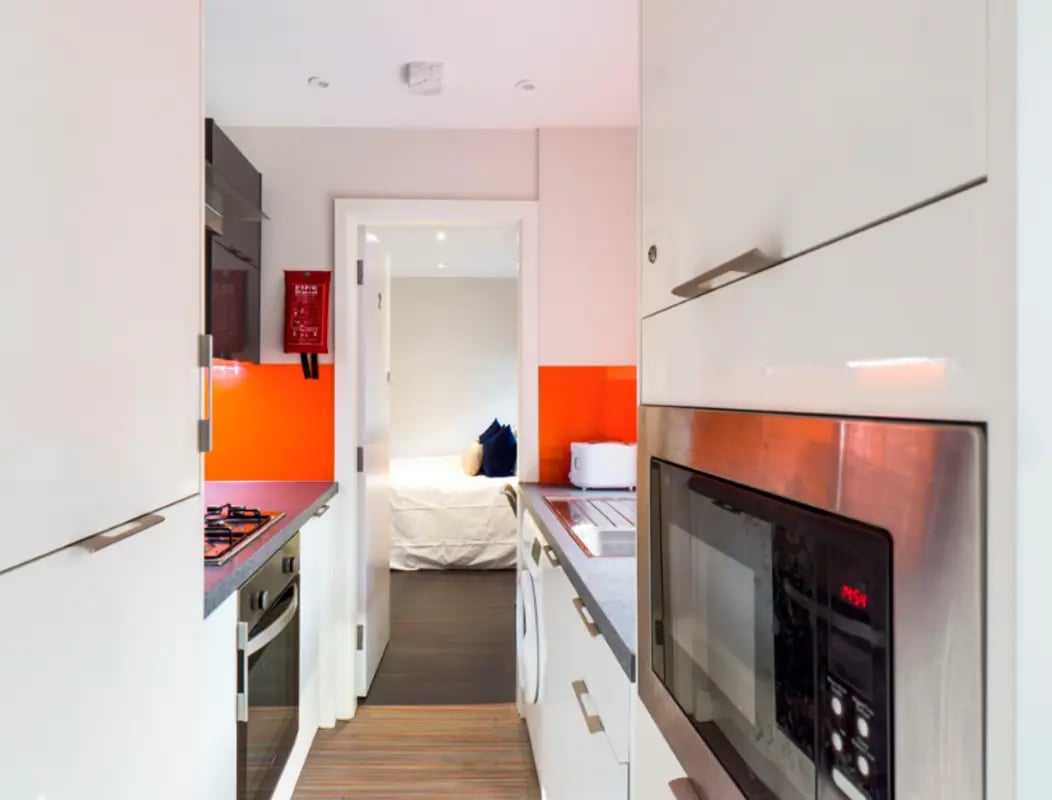 Modern kitchen with white cabinets microwave and stove kitchen at 21 Queen Anne Street in Stoke-On-Trent Student Accommodation
