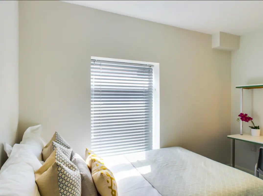 Bed pillows desk and flower bedroom at 21 Queen Anne Street in Stoke-On-Trent Student Accommodation