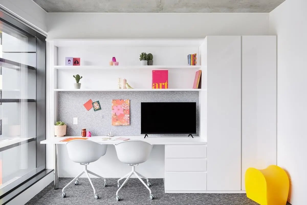 Desk with chairs and shelves computer display study area at Scape Carlton in Melbourne Student Accommodation