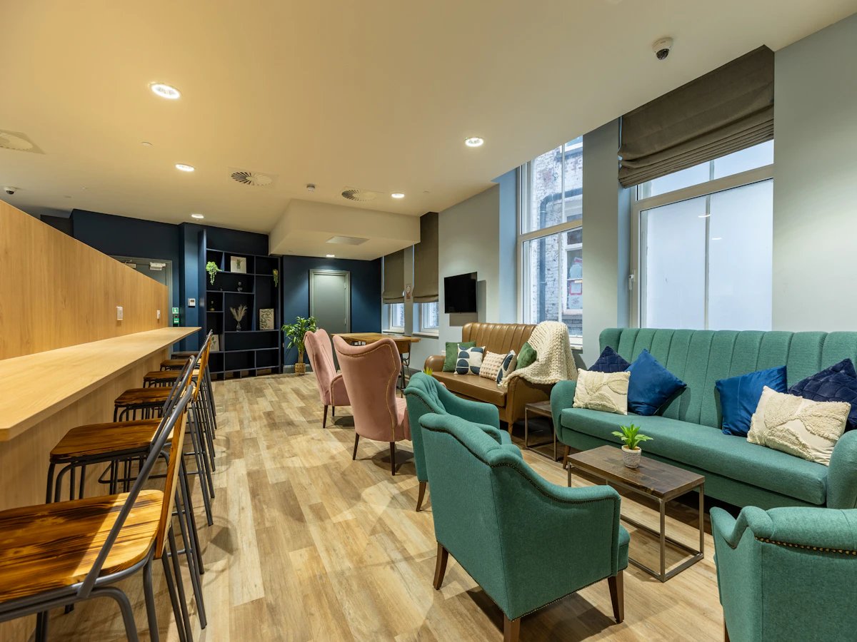 Seating area with sofas chairs and bar stools living room at Chamberlain Place in Birmingham Student Accommodation