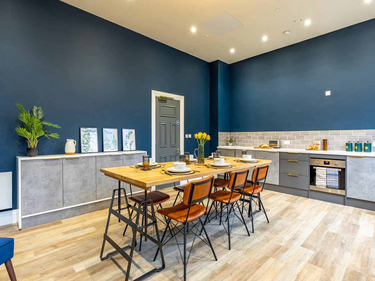 Dining table with chairs and kitchen counter kitchen at Chamberlain Place in Birmingham Student Accommodation