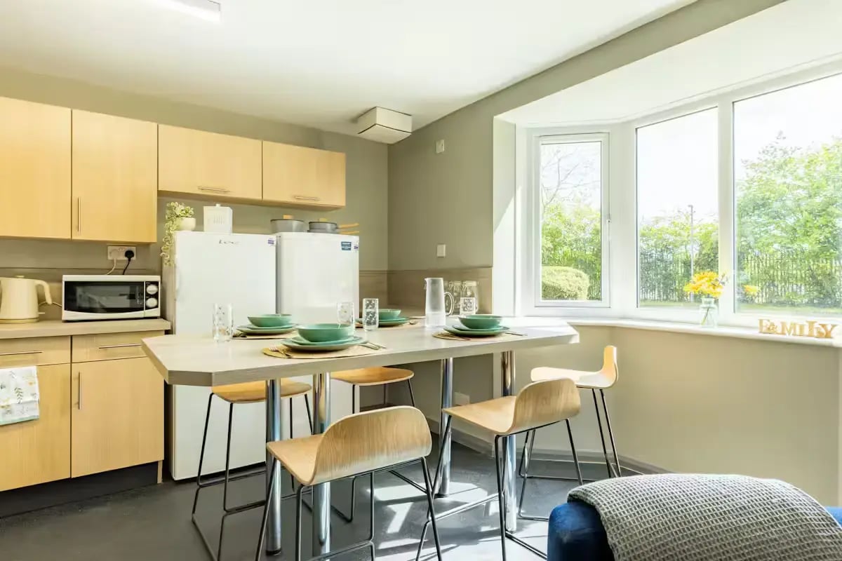 Kitchen island with stools refrigerators and microwave kitchen at Calthorpe Court in Birmingham Student Accommodation