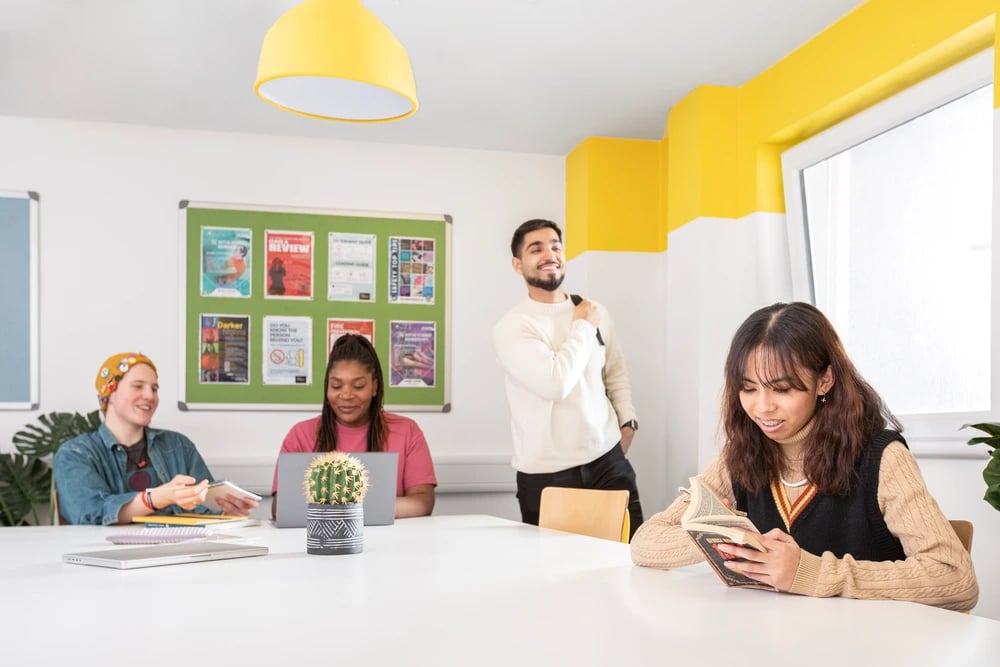 Students studying at tables with laptops and books common room at Mary Sturge in Birmingham Student Accommodation