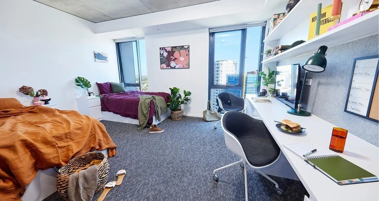 Two beds desk and chairs bedroom at Scape Redfern in Sydney Student Accommodation