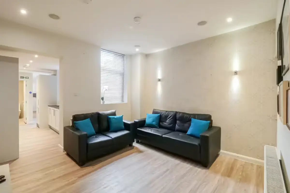 Two black sofas with blue cushions living room at 51 Beresford Street in Stoke-On-Trent Student Accommodation