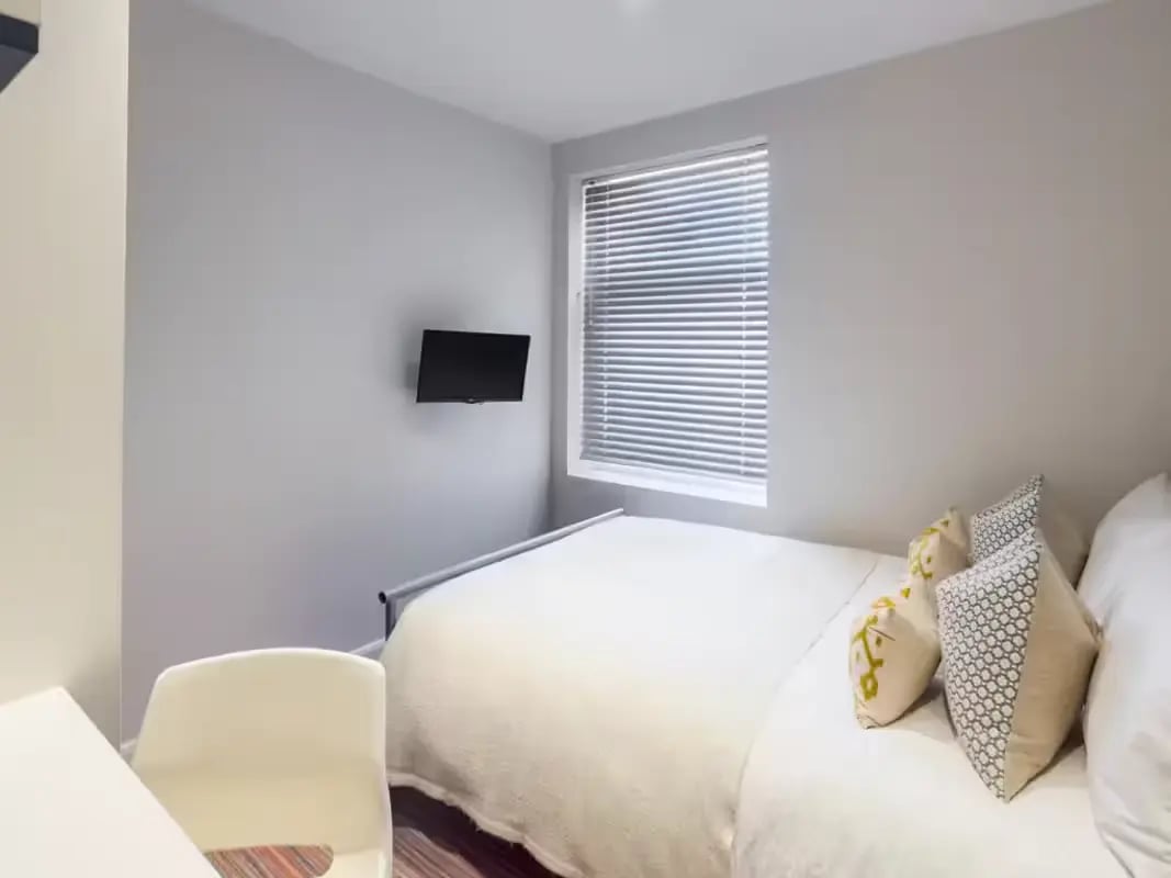 Bed with pillows TV on wall chair and desk bedroom at 41 Crowther Street in Stoke-On-Trent Student Accommodation