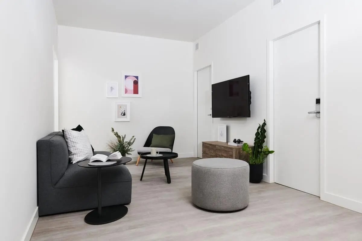 Sofa chair ottoman television artwork living room at Scape Cornell Place in Melbourne Student Accommodation