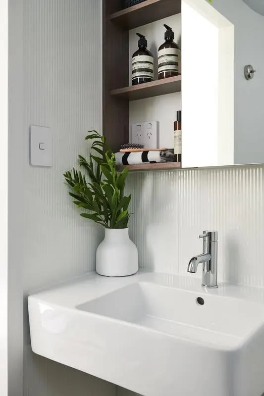 Sink plant and toiletries in bathroom at Scape Cornell Place in Melbourne Student Accommodation
