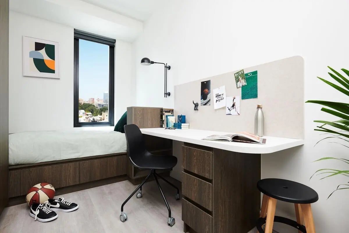 Bed desk chair basketball sneakers bedroom at Scape Cornell Place in Melbourne Student Accommodation