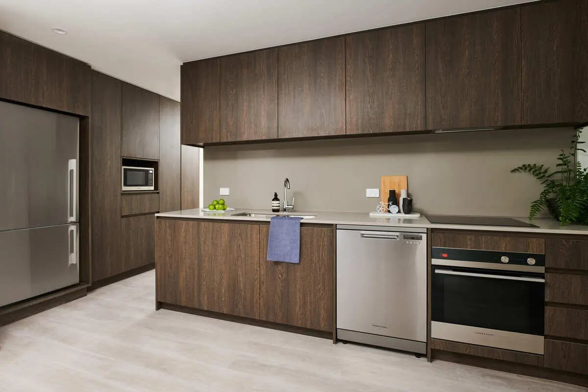 Modern kitchen with dark wood cabinets and appliances kitchen at Scape Cornell Place in Melbourne Student Accommodation