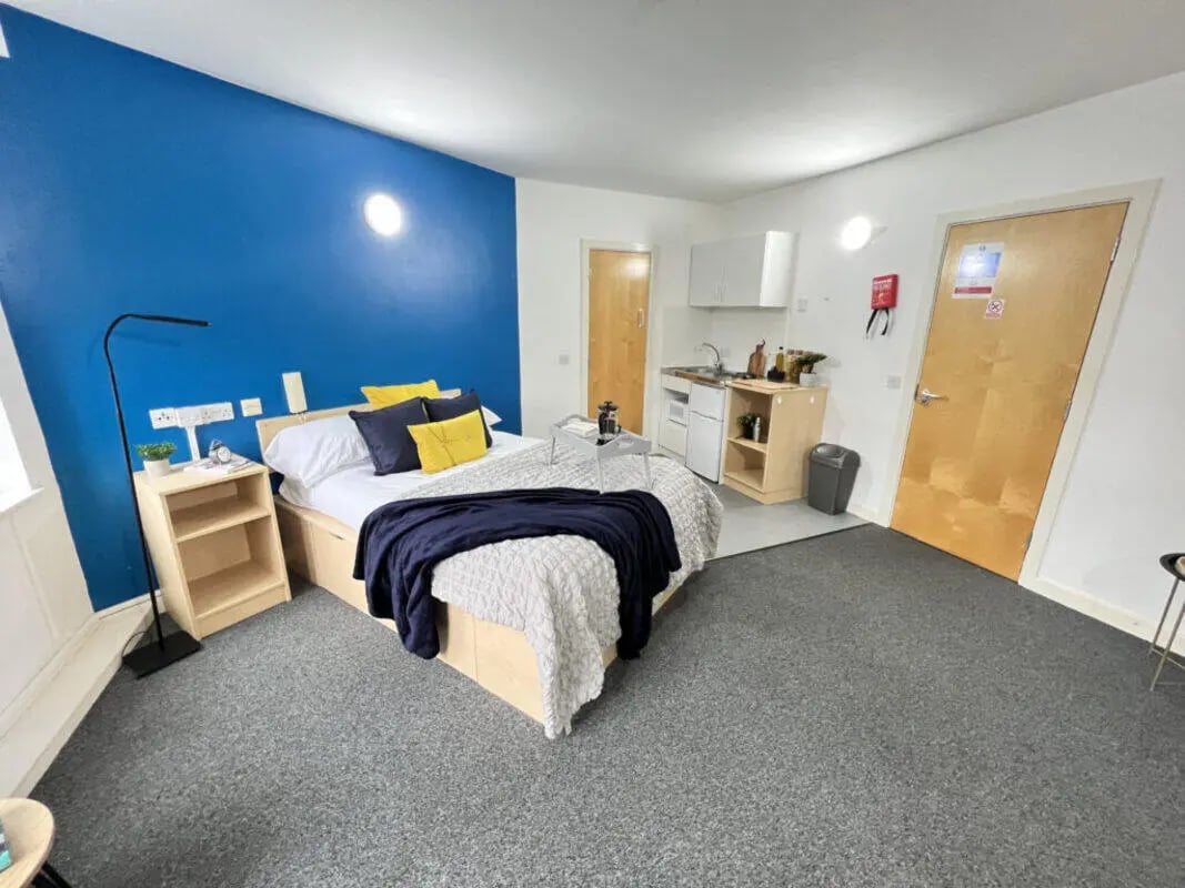 Bed kitchen area with blue wall study area exterior at Dunn House in Sunderland Student Accommodation