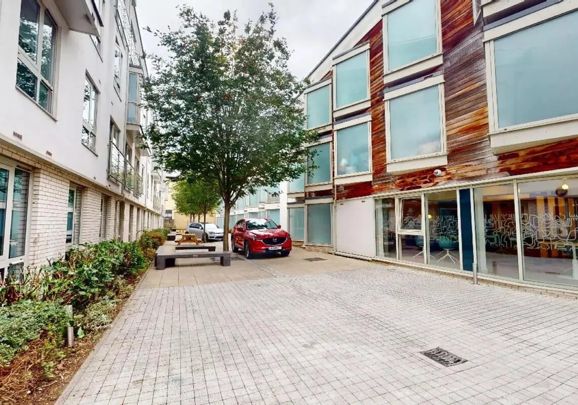 Courtyard with cars benches and buildings Exterior at iQ Hoxton in London Student Accommodation