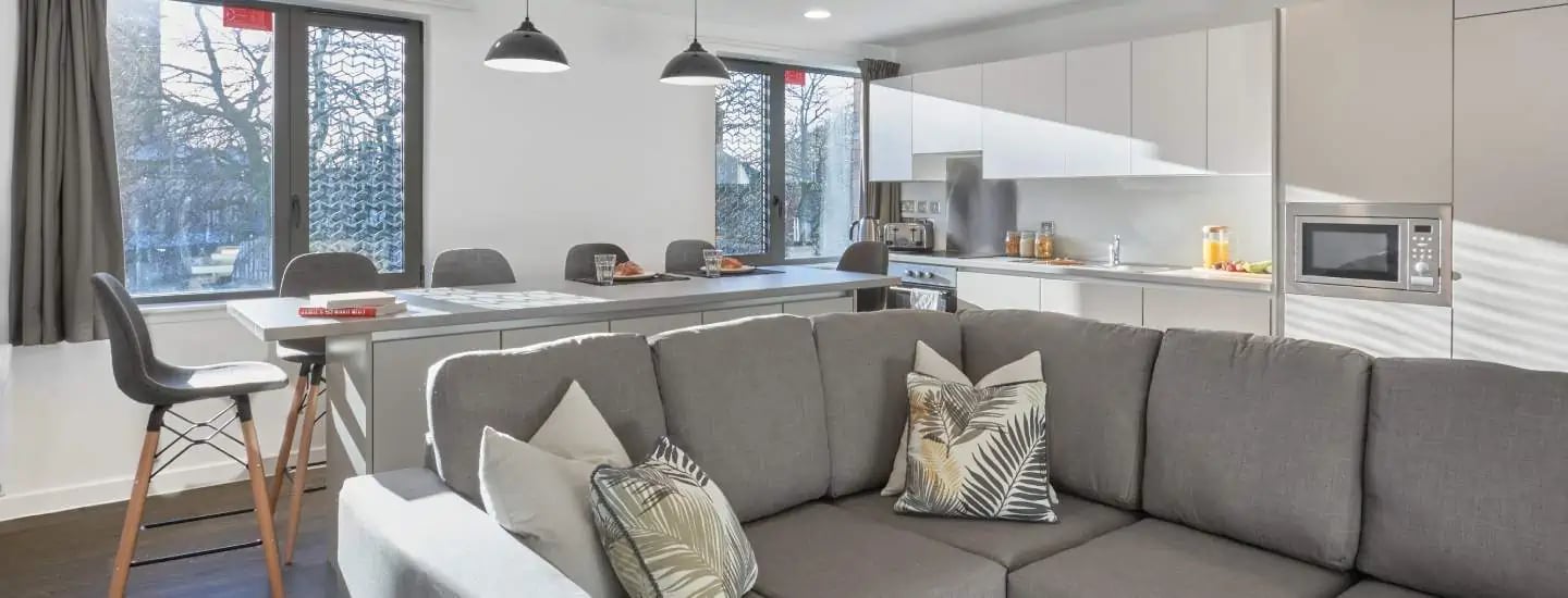 Sofa kitchen counter and dining table living area at The Glassworks Leicester in Leicester Student Accommodation