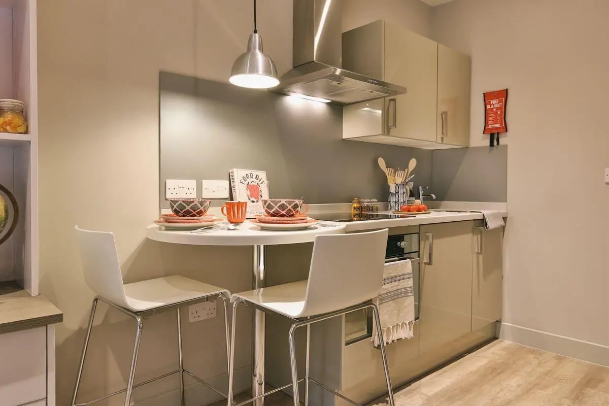 Bar table with chairs and kitchen counter kitchen at Kingsmill Studios in Huddersfield Student Accommodation