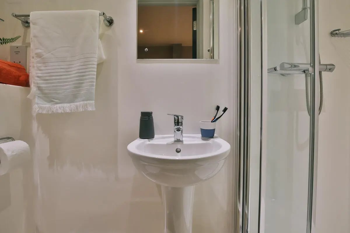 Sink toothbrush holder mirror and shower cubicle bathroom at Kingsmill Studios in Huddersfield Student Accommodation