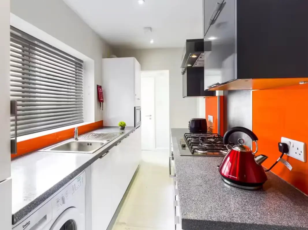Sink washing machine gas hob red kettle kitchen at 31 Guildford Street in Stoke-On-Trent Student Accommodation