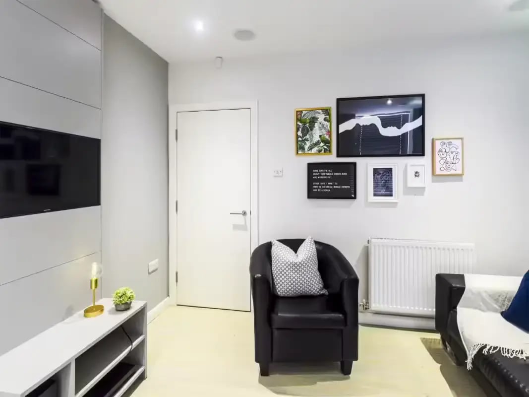 Black armchair with patterned cushion art and TV living room at 31 Guildford Street in Stoke-On-Trent Student Accommodation