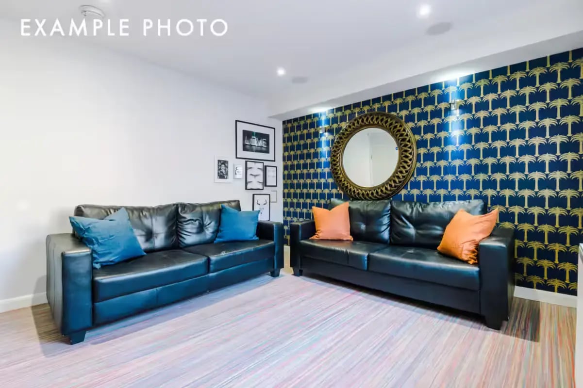 Two black sofas with cushions and mirror living room at 80 Beresford Street in Stoke-On-Trent Student Accommodation