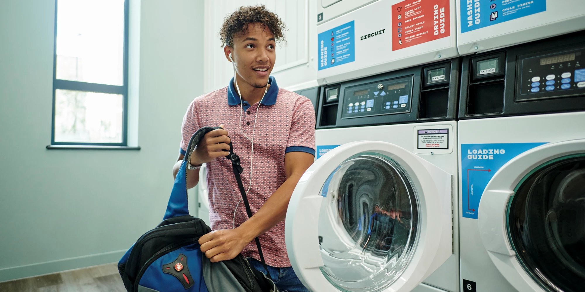 Man with backpack near washing machines laundry room at Canvas Bristol in Bristol Student Accommodation