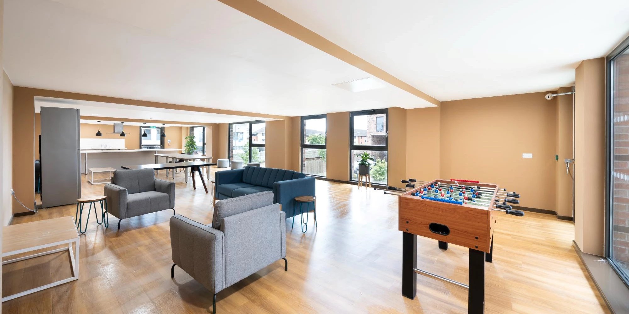 Foosball table couches chairs kitchen area living room at Canvas Glasgow in Glasgow Student Accommodation