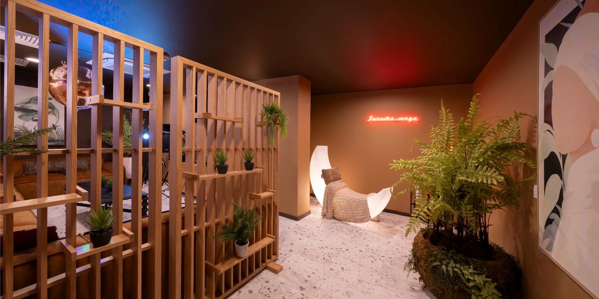 Wooden divider plants neon sign moon chair lounge at Canvas Glasgow in Glasgow Student Accommodation
