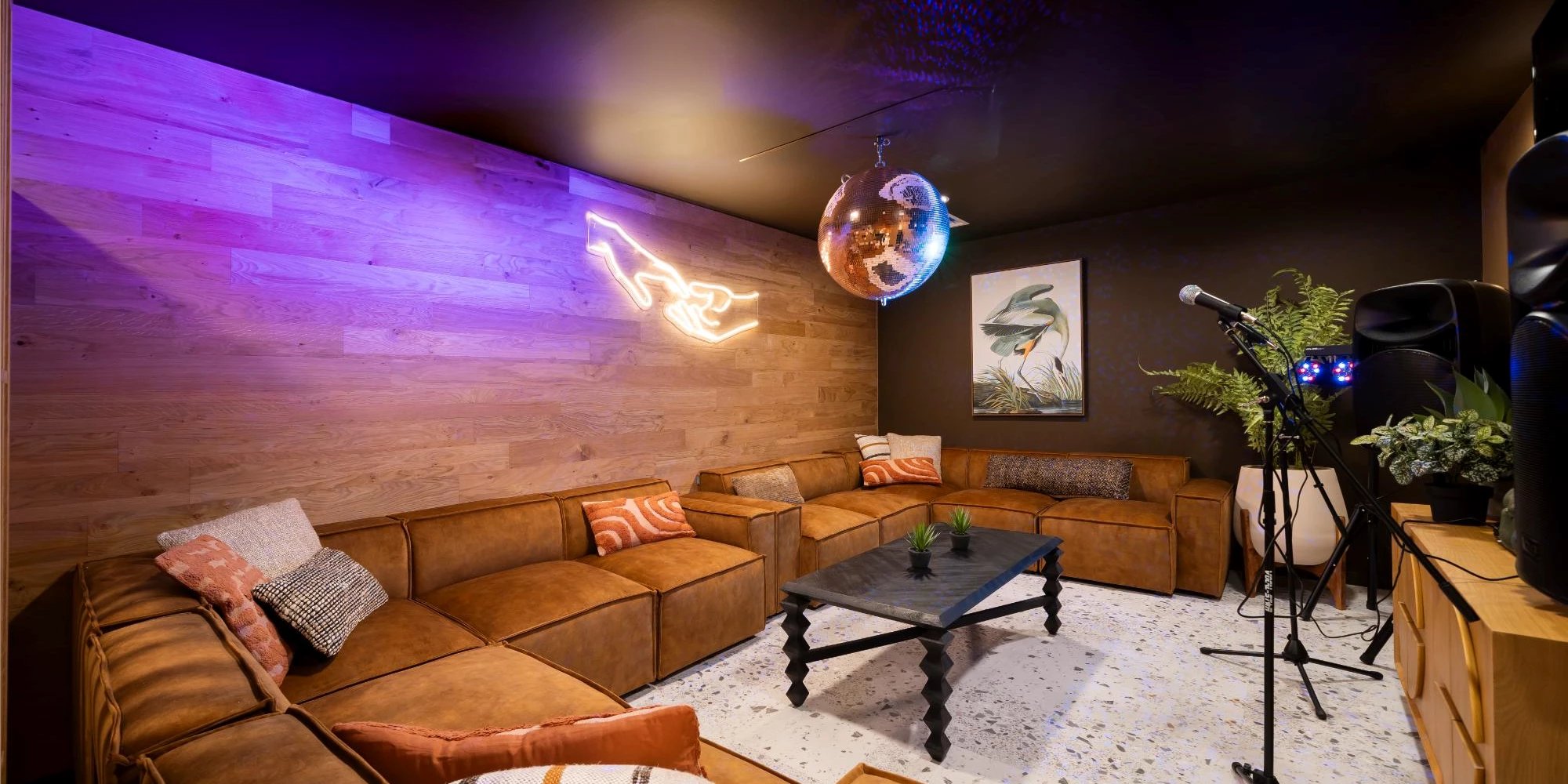 Tan sofas neon sign disco ball entertainment living room at Canvas Glasgow in Glasgow Student Accommodation
