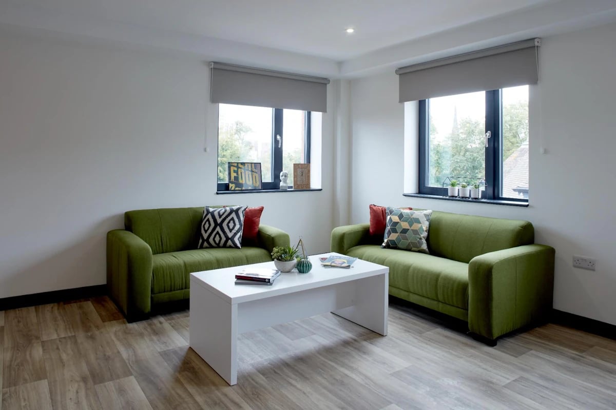 Two green sofas white table living room at Eden Square in Coventry Student Accommodation