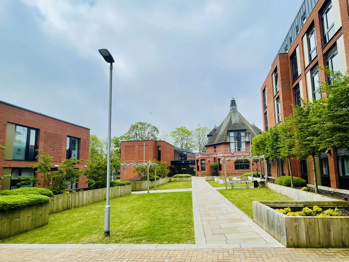 Courtyard with brick buildings and green lawn exterior at Eden Square in Coventry Student Accommodation