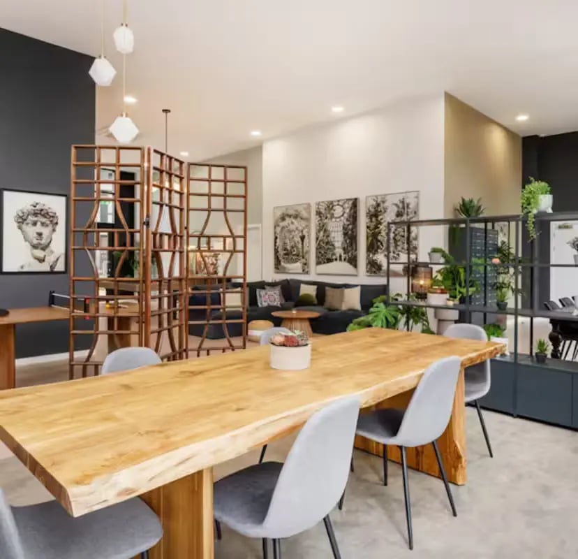 Wooden table chairs artwork and sofa communal area at Zinc Quarter in Bristol Student Accommodation