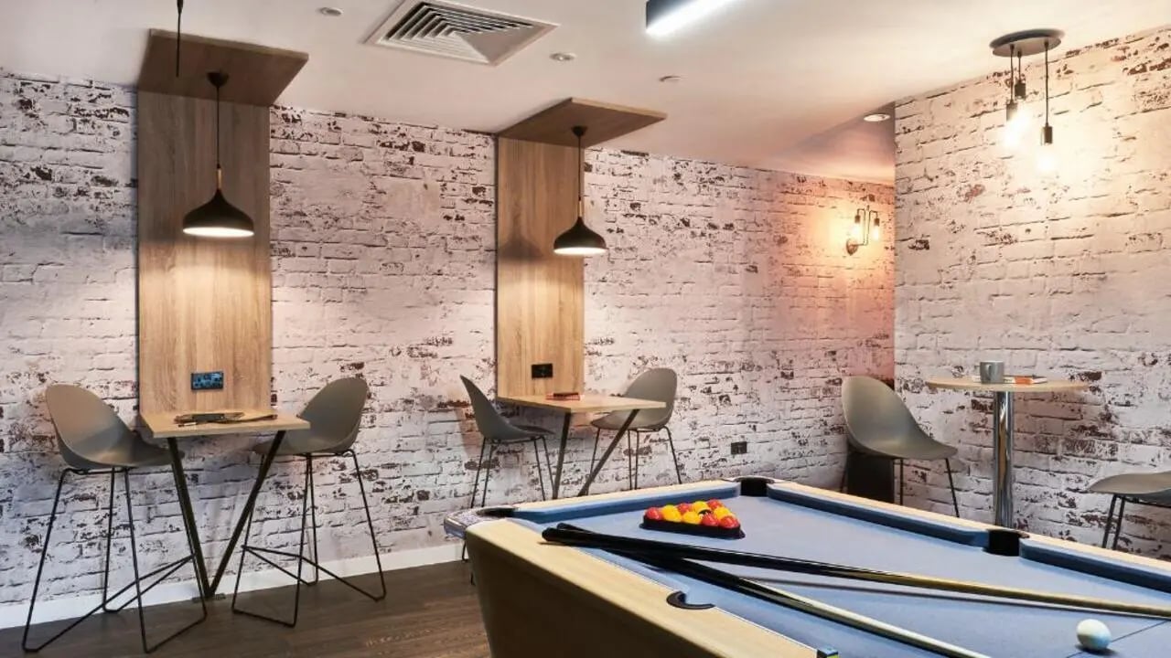 Pool table, tables, chairs, brick wall, common area at 41 Castle Street in Leicester Student Accommodation
