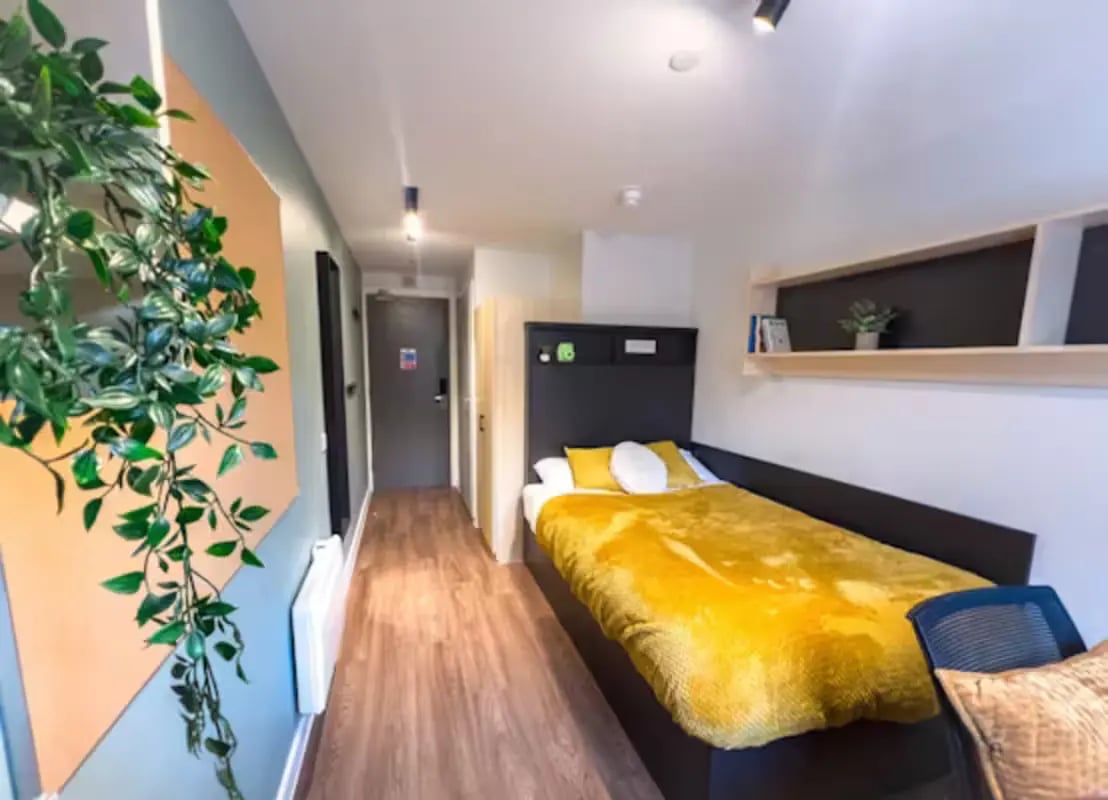 Bed with yellow blanket and white pillow bedroom at Portsburgh Court in Edinburgh Student Accommodation
